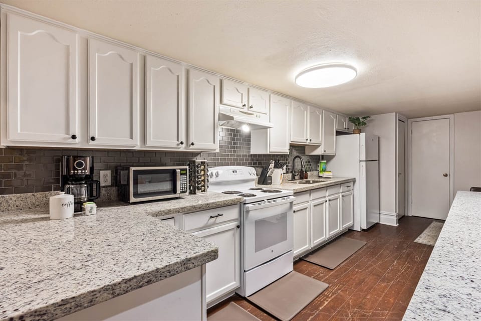 Your fully equipped kitchen features granite counters, white cabinetry, and all appliances needed for memorable meals during your stay.
