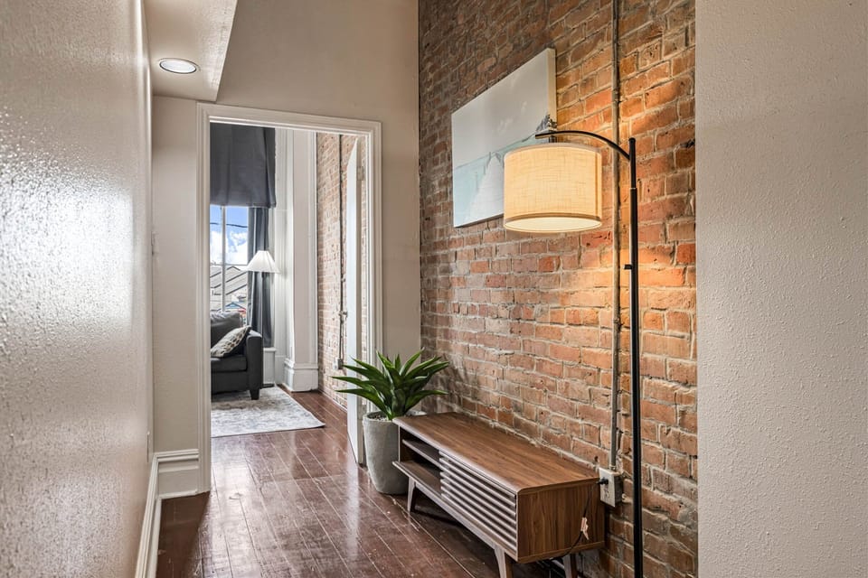 Step into your stylish loft where exposed brick walls and warm lighting create an inviting urban retreat that feels like home.