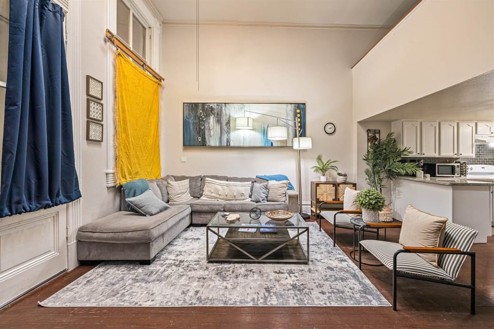 Relax in your thoughtfully designed living space with plush seating, modern art, and an open kitchen—perfect for unwinding after exploring.