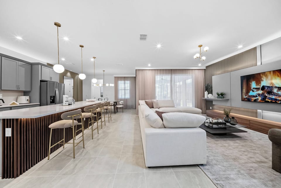 Enjoy a stylish blend of comfort and sophistication in this spacious living area, featuring soft tones and sleek furnishings. The cozy sectional invites relaxation, while the modern kitchen island enhances your entertaining.