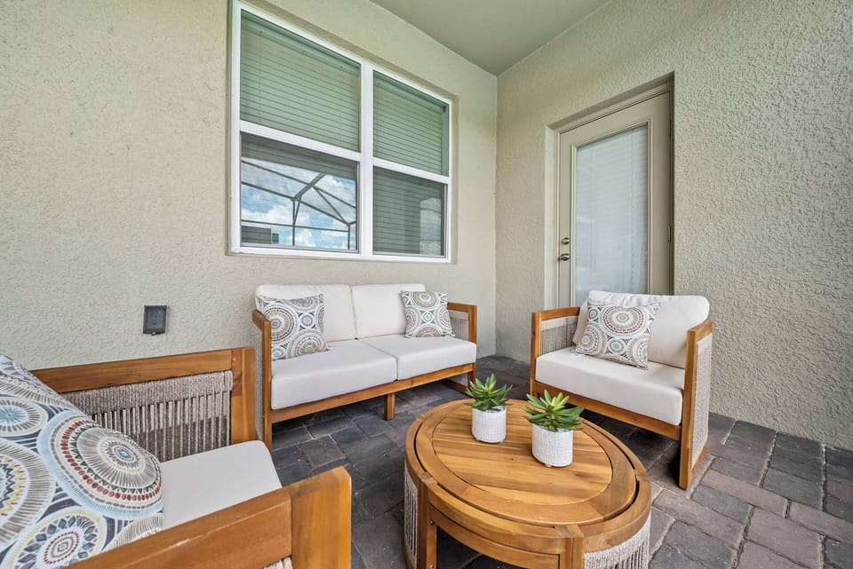 Step outside to a charming seating area with soft cushions perfect for relaxation. The warm wooden coffee table adds a rustic touch, while natural light creates a welcoming atmosphere for morning coffee or evening chats.