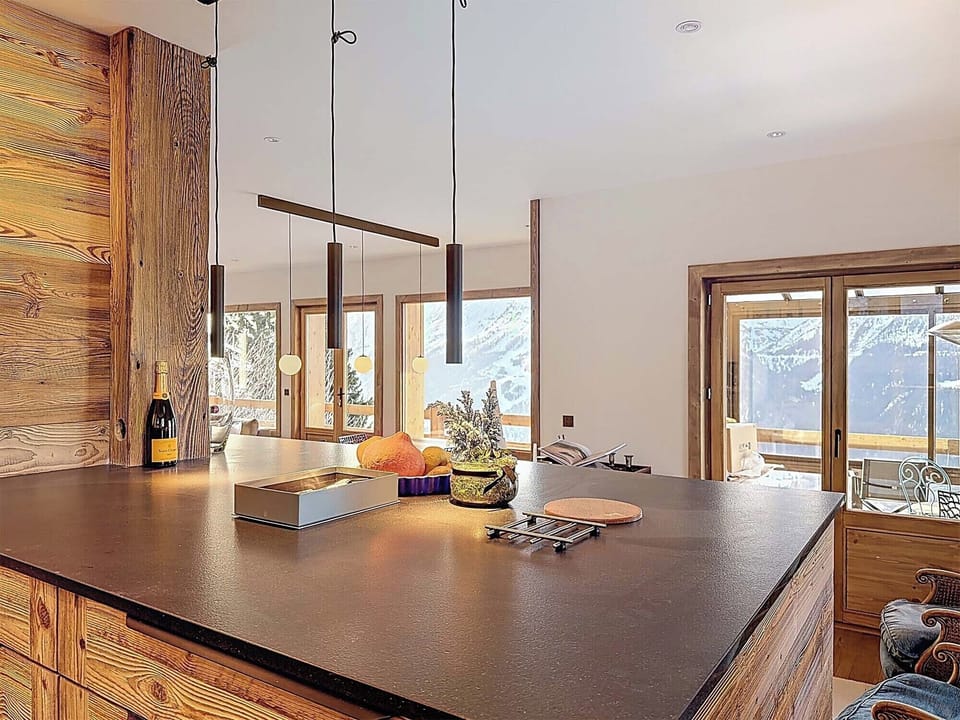 Stylish kitchen island and living space designed for entertaining, offering seamless access to the balcony and breathtaking valley scenery.