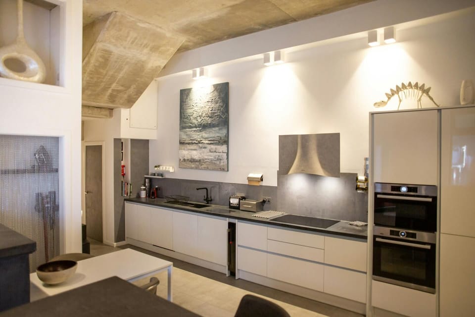 Kitchen with ovens, hob and extractor, sink, table and chairs and breakfast bar