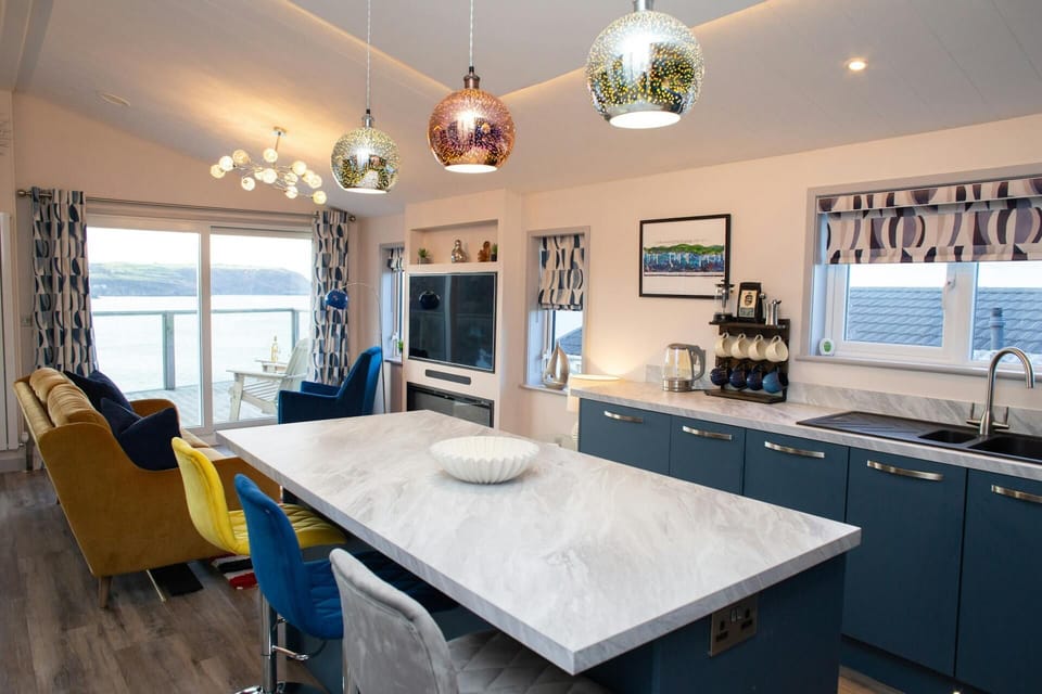 Modern kitchen-diner with island, pendant lights, and seating near patio doors