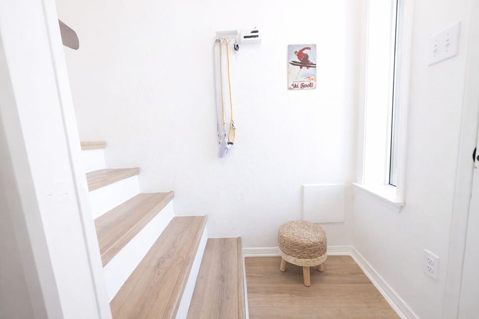 Bright, airy entry with window, hooks, and woven stool