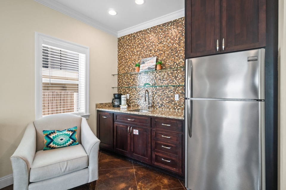 Downstairs living room features a modern wet bar with sink and full size refrigerator
