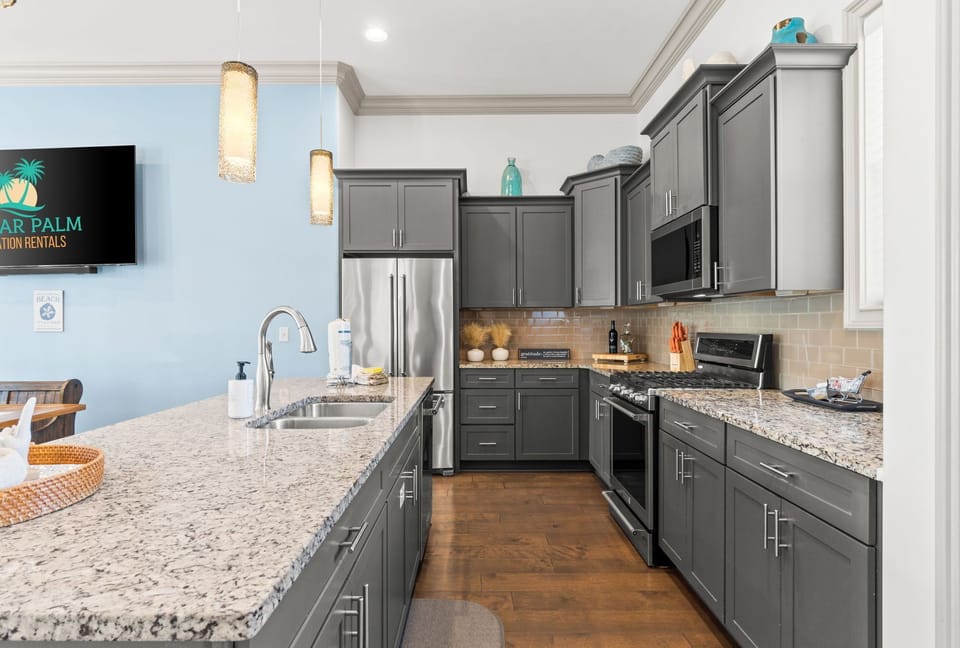 Entertainer-friendly kitchen with bar stools, modern appliances, and an open view of the dining room and living space.