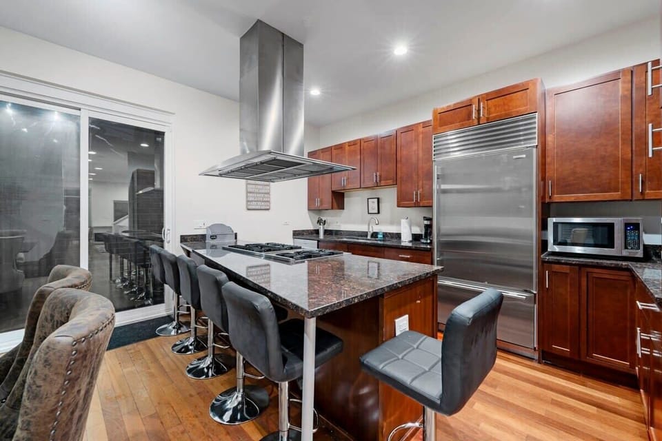 Open kitchen w/ island seating, stainless appliances, & easy flow for cooking, dining, or late-night snacks.