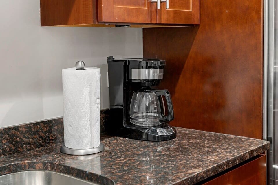 Kitchen counter setup w/ coffee maker & essentials ready for easy mornings or late-night refills.