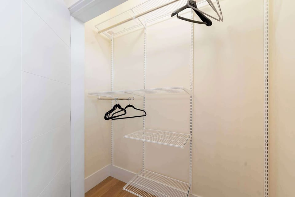Open closet area w/ hangers ready to keep clothes organized & easy to access.