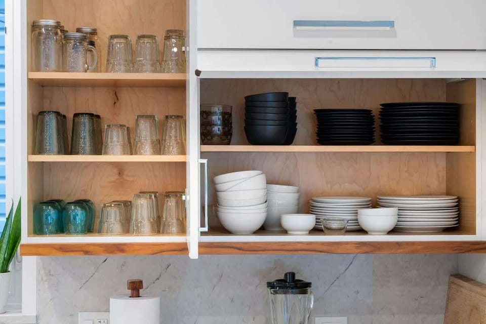 Well-organized cabinets stocked w/ plates, bowls, & glasses for easy everyday use.