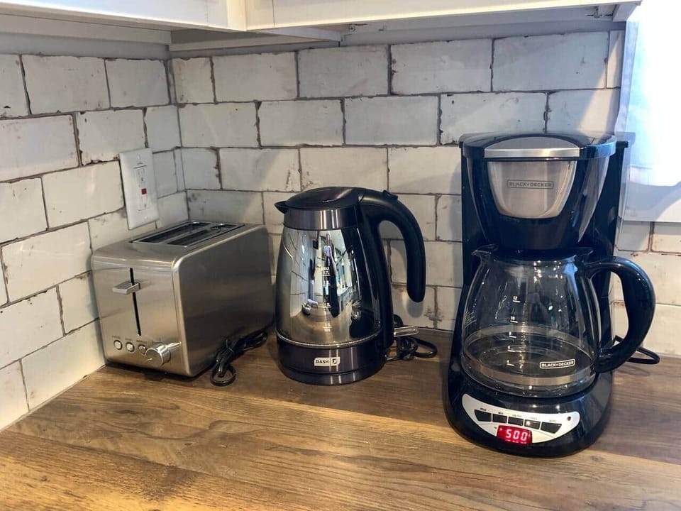 A coffee bar with organic coffee above the these appliances. The kitchen is fully stocked with dinnerware, glasses, and silverware.  Stainless steel cookware, and bakeware, mixers, and baking trays. Everything you need to create wonderful meals! 