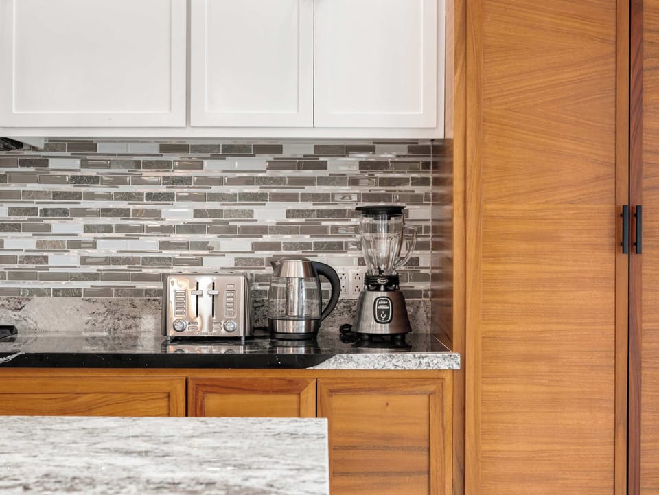 Modern kitchen corner w/ ample storage, stylish backsplash, and thoughtful touches throughout.