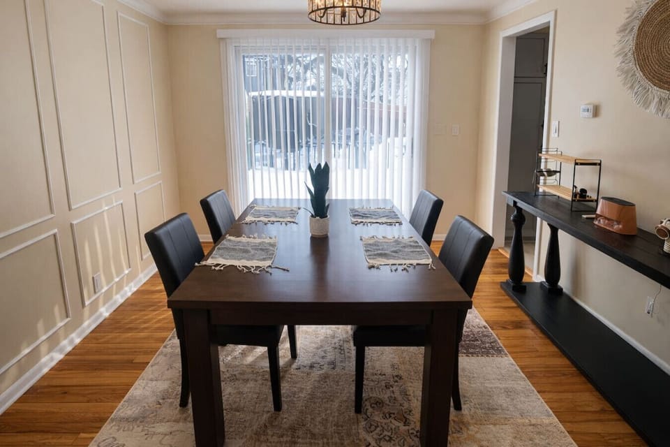 Featuring a spacious dark wood table and a statement chandelier, it’s the perfect spot for everything from a quick breakfast to a celebratory dinner. The open-concept layout keeps you connected to the living room, ensuring a bright and social atmosphere f