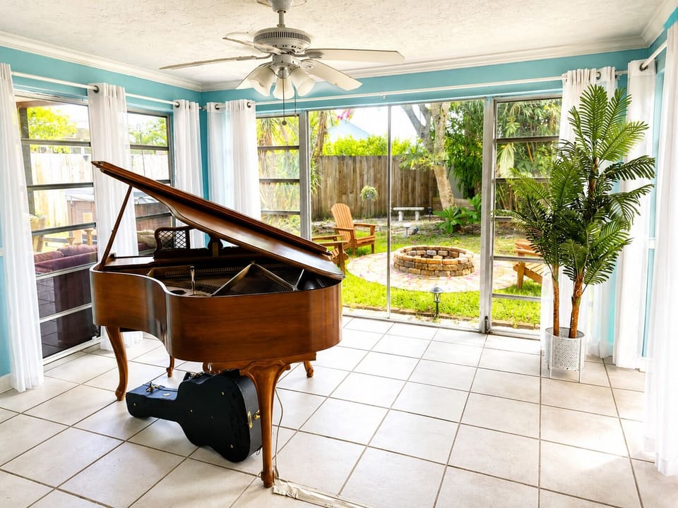 Florida room with guitar hanger for the musician in you.  Overlooking the new fire pit.  Beautiful playing player piano.  