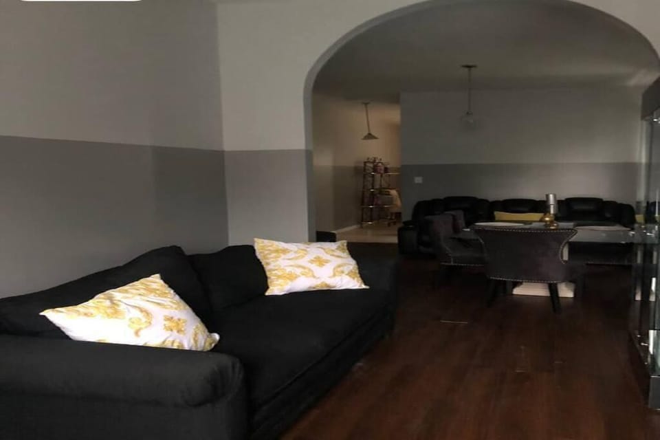 Living room with HDTV “55” with archway to dining room and kitchen.