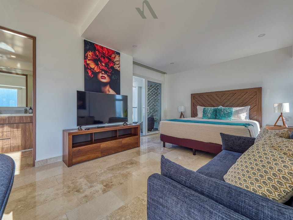 Primary suite with a king bed, seating area, and modern furnishings designed for comfort and privacy.