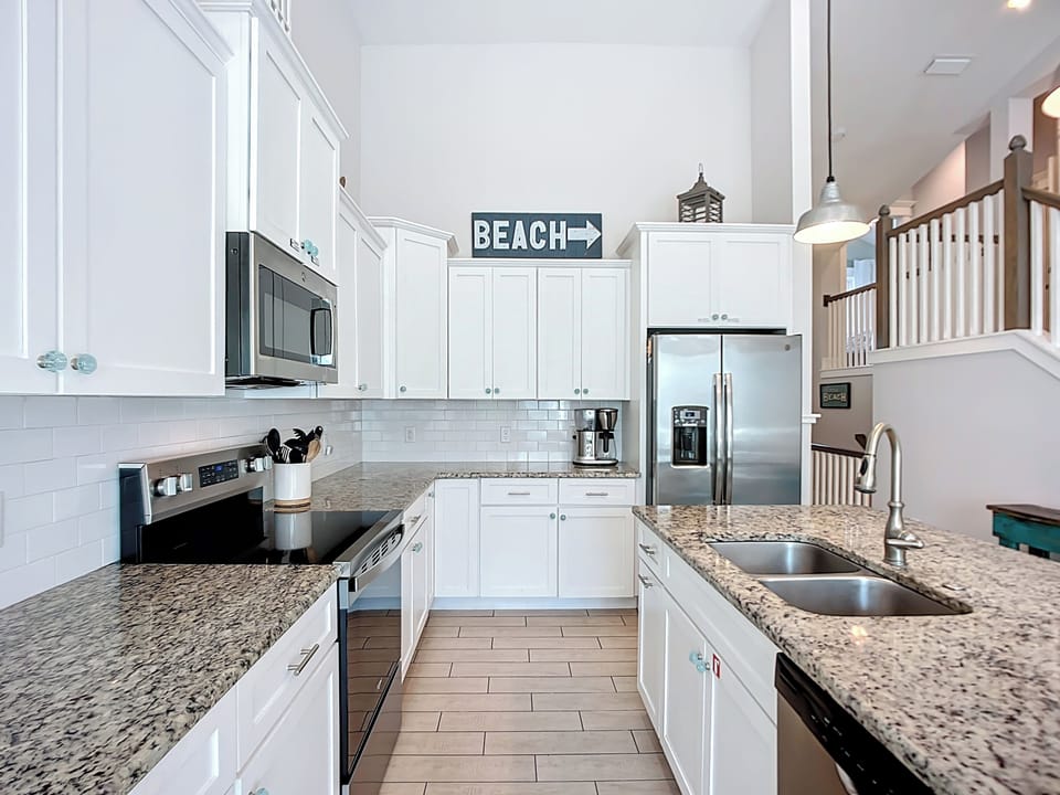Your gourmet kitchen awaits with granite counters, stainless appliances, and charming beach-themed touches that make cooking feel like a coastal retreat.