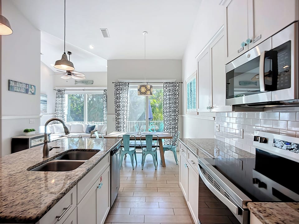 Prepare meals in your modern kitchen with granite counters and stainless appliances, while sunlight streams through windows.