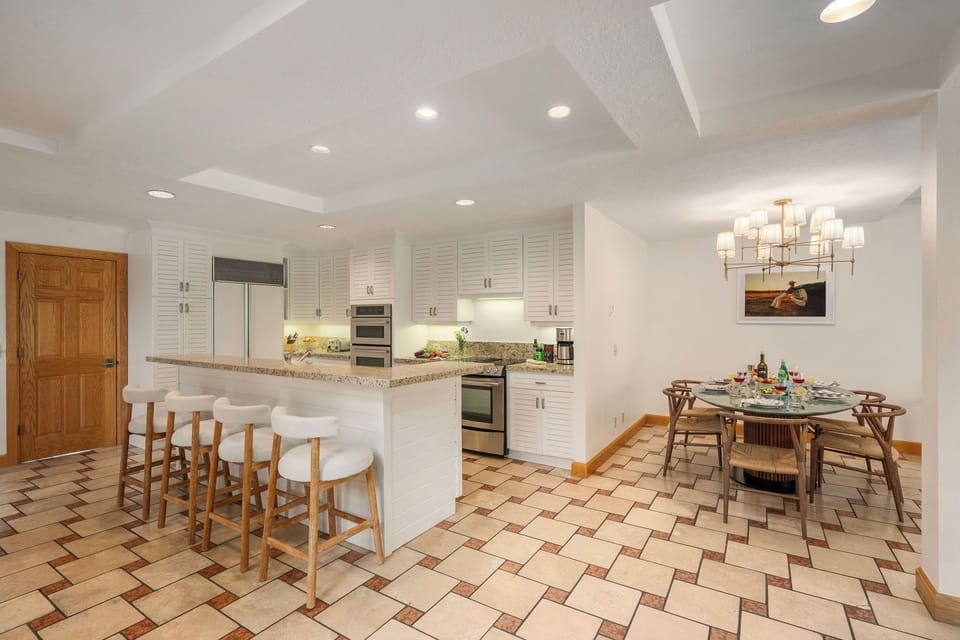 Your bright, open kitchen flows seamlessly into the dining space, featuring granite countertops, modern appliances, and a breakfast bar perfect for morning coffee or evening conversations.