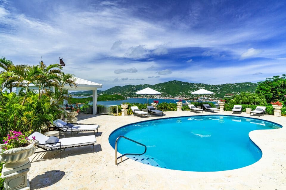 The expansive pool and pool deck with sun loungers and umbrellas.