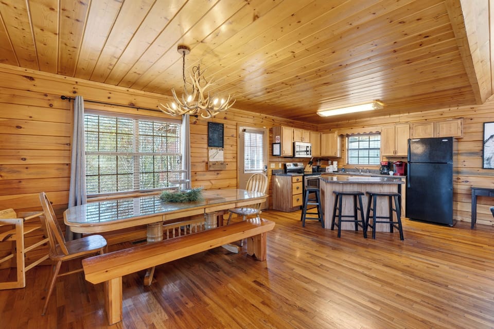 Dining area with a view of the kitchen, featuring an antler-style chandelier.