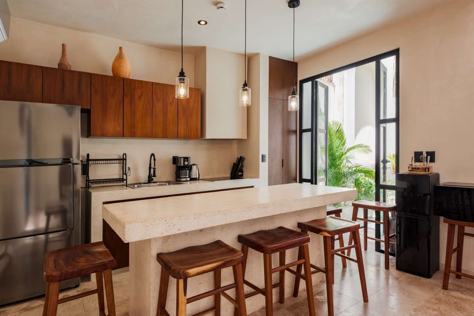 Chef's kitchen with dark wood cabinetry, stone countertops, pendant lights, and premium appliances.