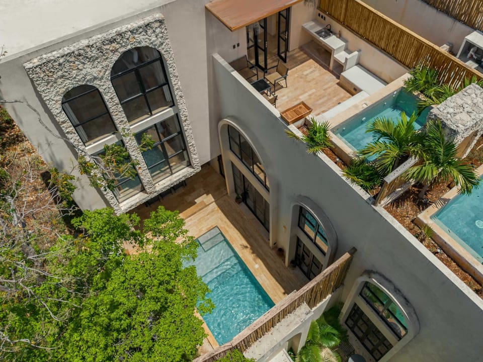 Aerial drone view of private rooftop pool with turquoise water and Tulum rooftop panorama.