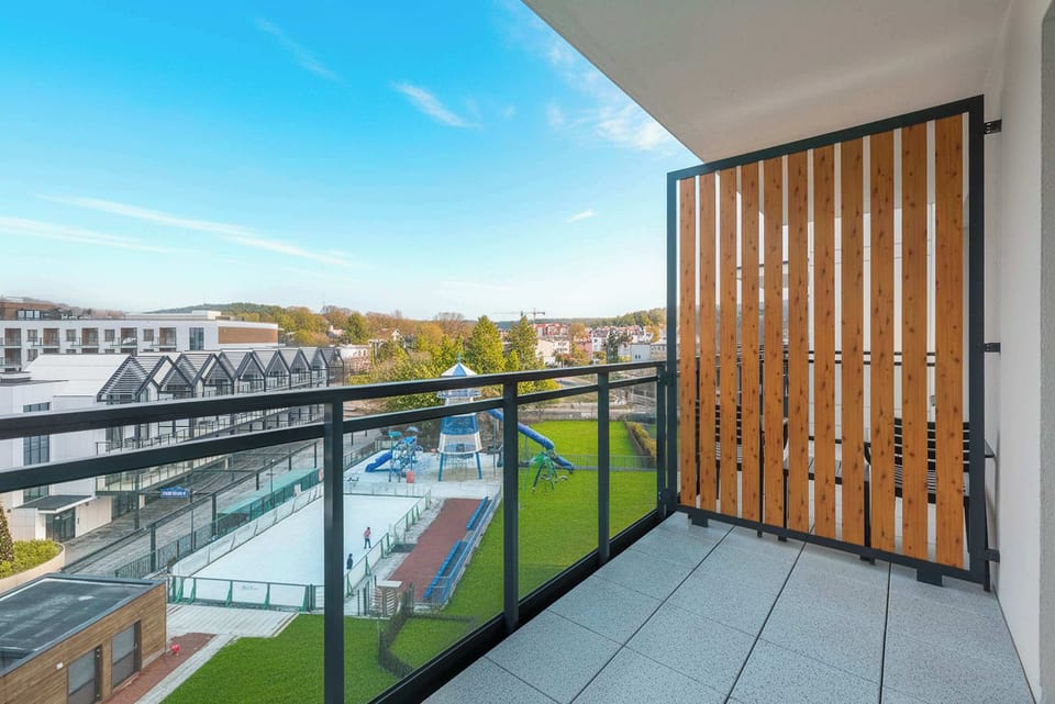 A balcony with a railing, seating area, and partial view of the surroundings. It offers a private outdoor space for relaxation.