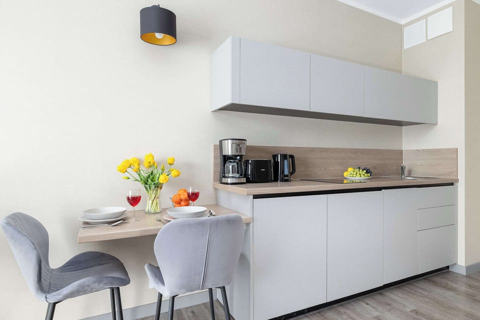 A small dining area within the kitchen, including a table set for two and modern cabinetry. It’s ideal for casual meals or coffee breaks.
