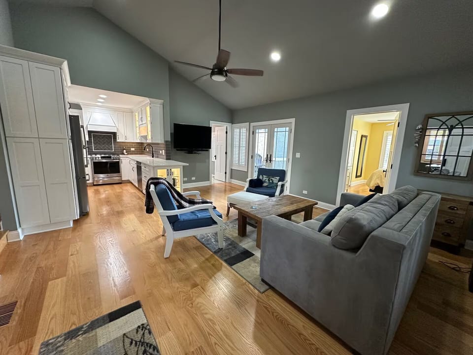 Vaulted ceiling, has sofa bed, chairs and coffee table, and ceiling fan