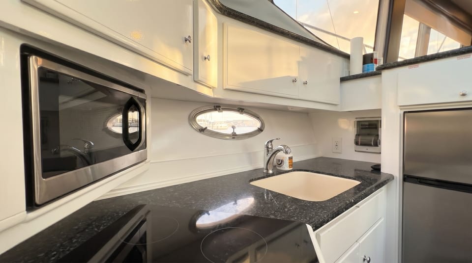 Galley kitchen with a sink, dark counters, and storage in updated finishes
