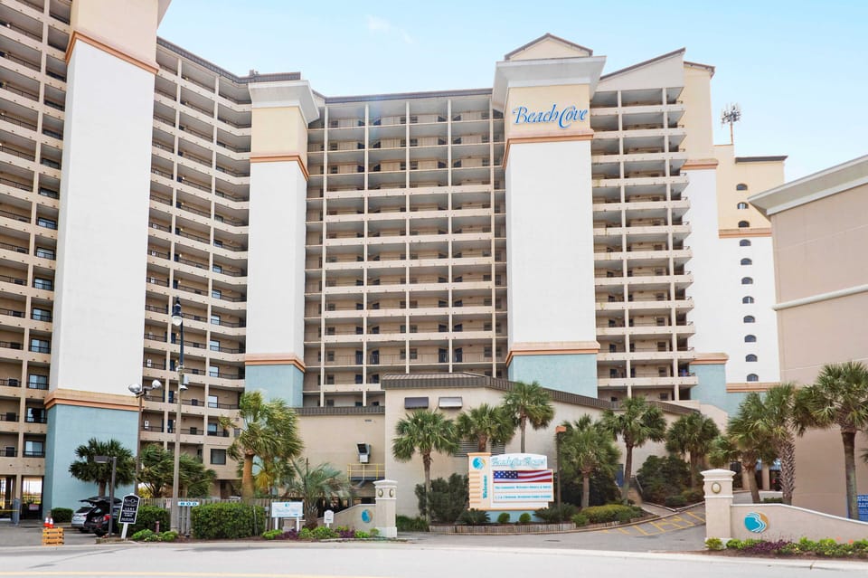 Palm-lined resort tower with balconies by the beach—easy access