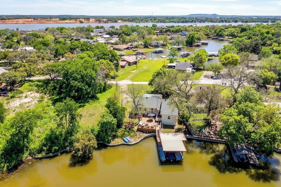 Aerial view of backyard, private dock, and canal access to Lake Granbury — true waterfront living.
