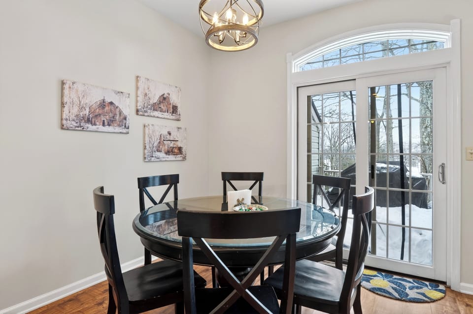 Elegant circular dining table with seating for six near the patio doors.