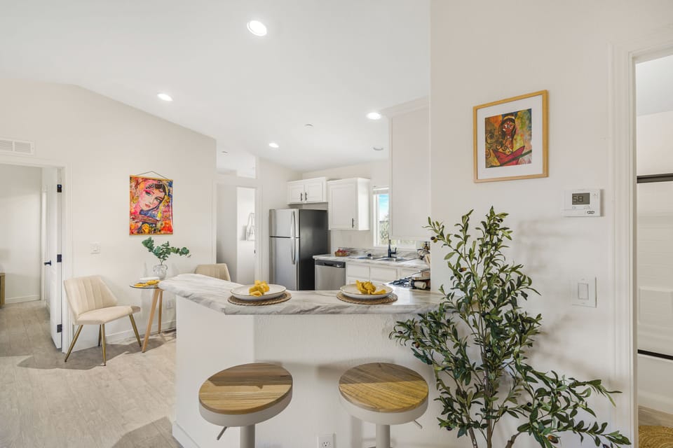 Open, inviting kitchen space with bar stools and a cheerful dining setup. (Bombay Chardonnay)