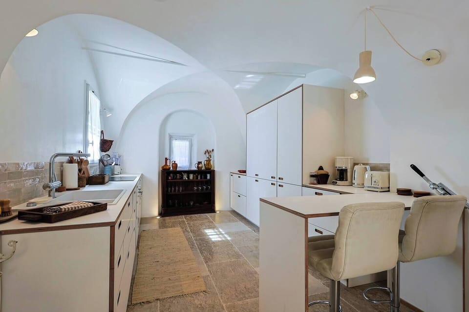 A full view of the kitchen showcasing clean lines, natural materials, and bar counter.