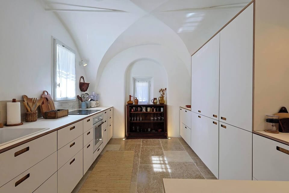 Fully equipped kitchen set beneath beautiful vaulted ceilings, combining modern comfort with historic character.