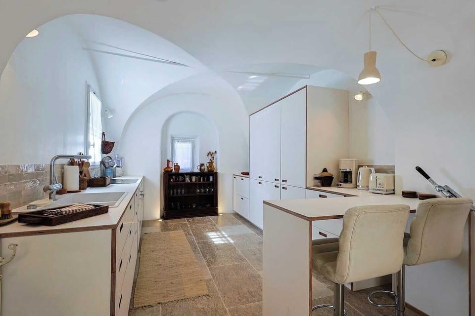Fully equipped kitchen set beneath beautiful vaulted ceilings, combining modern comfort with historic character.