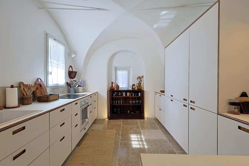 Fully equipped kitchen set beneath beautiful vaulted ceilings, combining modern comfort with historic character.