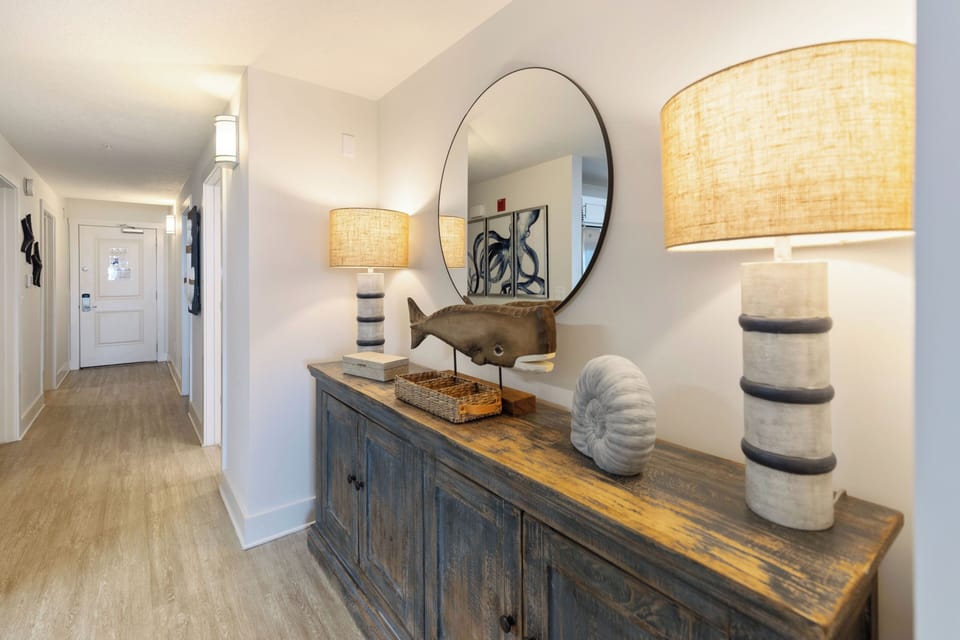 Your coastal-inspired hallway welcomes you with warm lighting and charming nautical touches that set the perfect relaxed vacation mood.