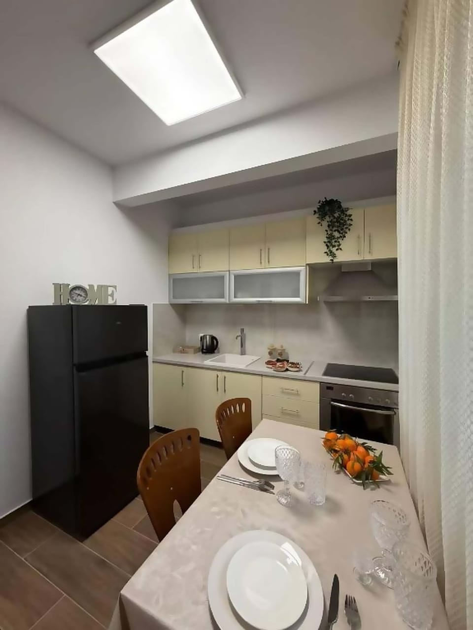 Kitchen and dining corner with refrigerator and storage space.