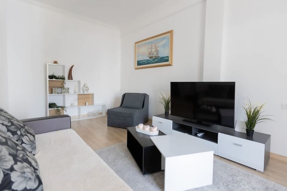Bright and welcoming living room with comfortable seating and a Smart TV for relaxing after a day in the city.