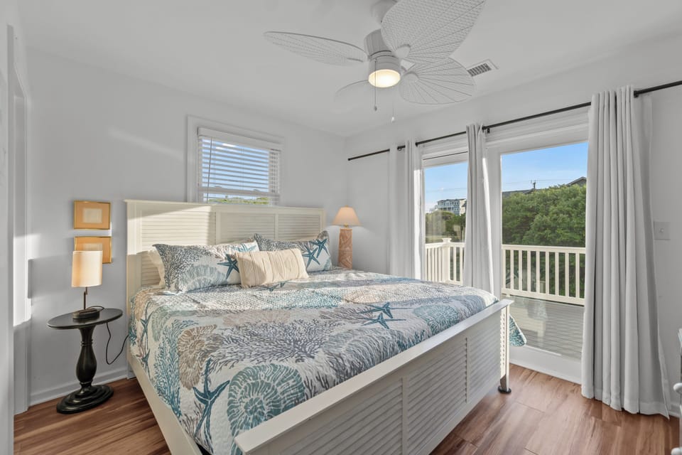 Bright coastal king bedroom with private balcony and serene views
