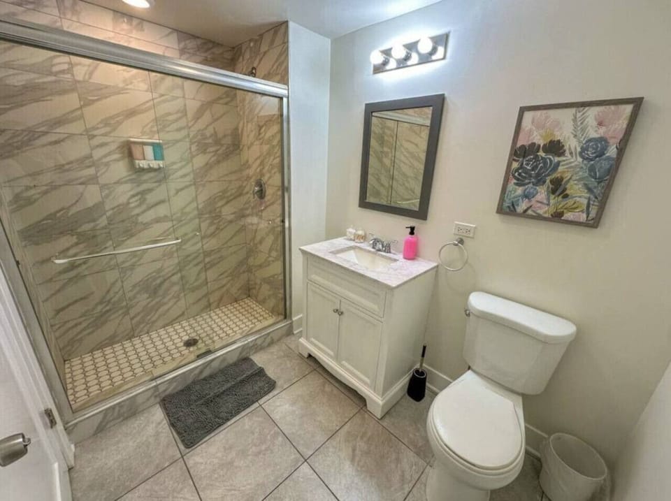 Modern bathroom with glass shower and bright lighting.