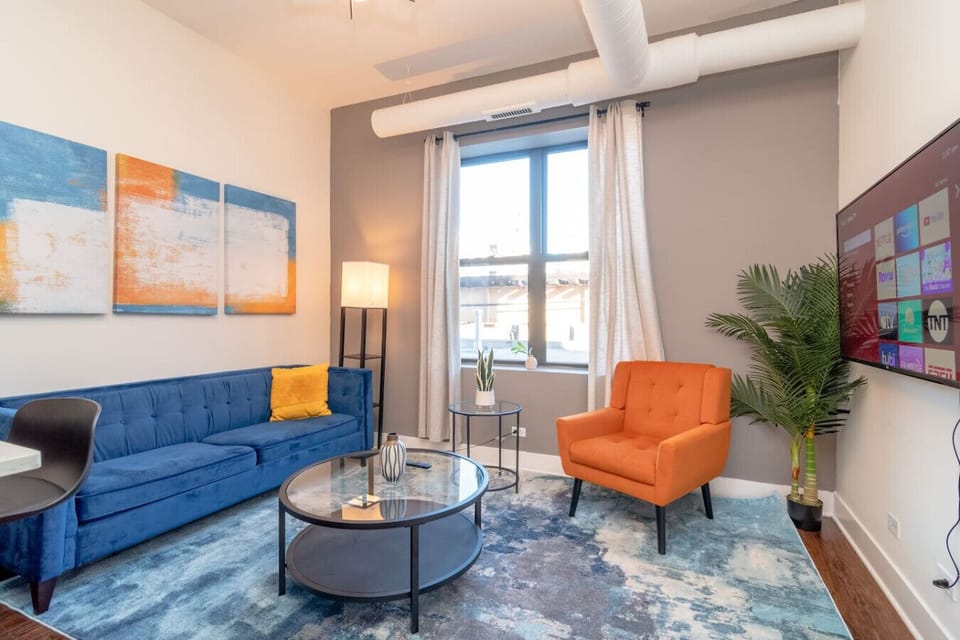 Bright living area with modern seating, large window, and contemporary decor.