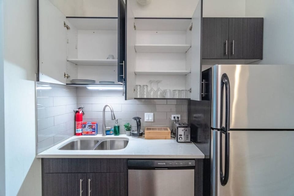 Bright open-concept living space with modern kitchen, high ceilings, and beautiful natural light.