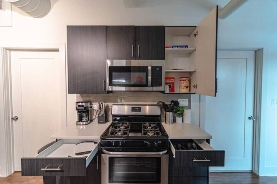 Fully equipped kitchen with gas stove, microwave, coffee maker, and ample cabinet space.