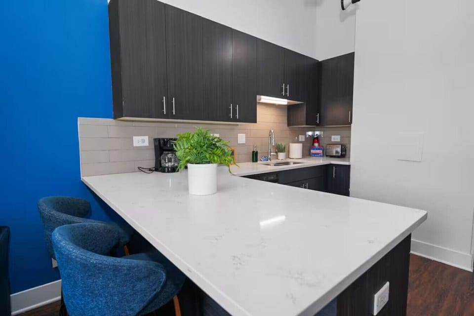 Bright open-concept living space with modern kitchen, high ceilings, and beautiful natural light.