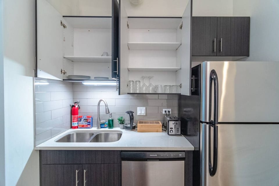 Stocked kitchen with dishes, glassware + dishwasher